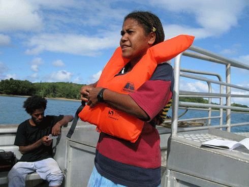 Through aid funding, this Vanuatu woman has been trained to operate a boat that ferries tourists between their cruise ship and the island.